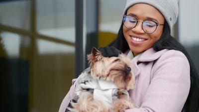 Woman Walking Cute Dog Outdoors on Winter Day.