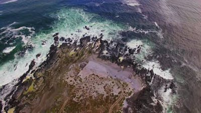 Aerial view of waves crashing on coastline.