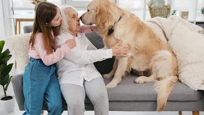 Grandmother and Granddaughter with Golden Retriever Dog.