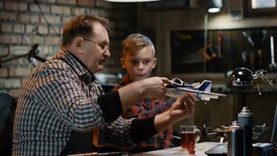 Grandfather with Grandson Repairing Toy Plane.