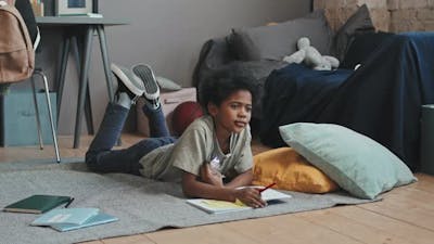 Boy Drawing and Eating Chocolate.