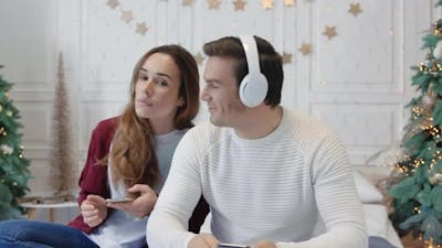 Happy Couple Enjoying Music in Earphones Together.