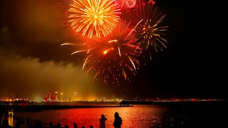 A constant display of fireworks iluminate the city and a lake on the Chinese New Year celebration.