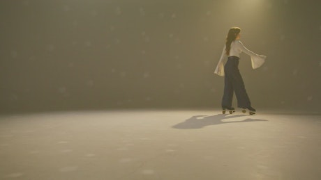 A young woman walking backguards on roller baldes.