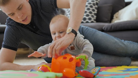 Baby playing with toys on the floor.