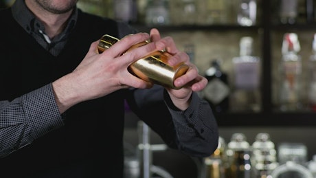 Barista waving a cocktail shaker.