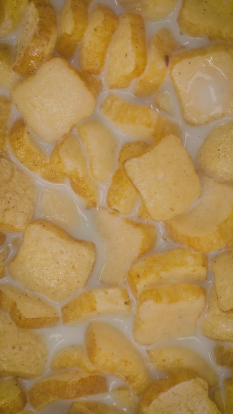 Bread shaped cereal texture in bowl with milk.