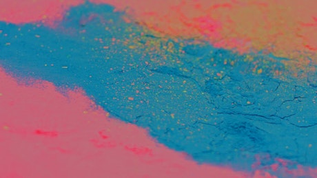 Colorful powder surface shaking in slow motion.