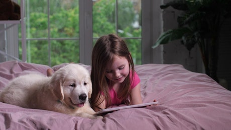 Girl and her puppy watching videos.