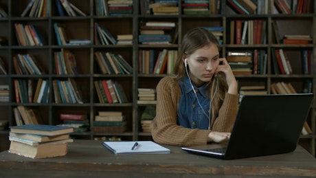 Girl doing homework in a library.