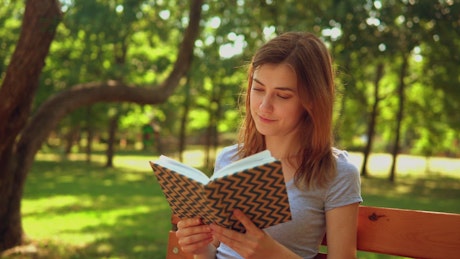 Girl reading a book in nature.