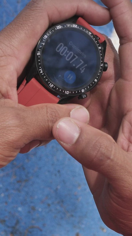 Hands holding a smart watch with the stopwatch running.