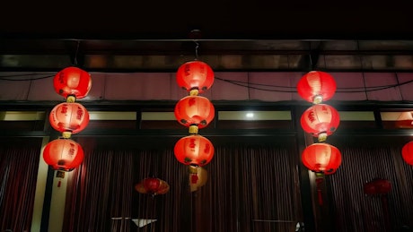 Lit red Chinese traditional lanterns move gracefully with the wind.