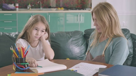 Mother helps her daughter study.