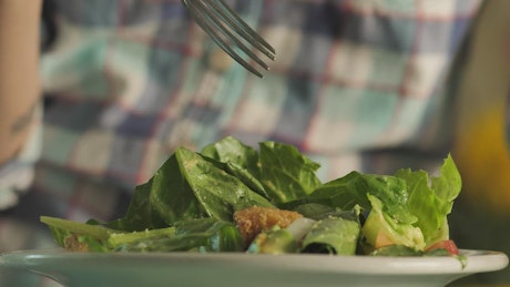 Person eating salad.