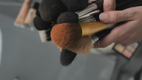 Placing many makeup brushes on a table.