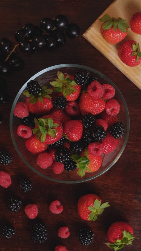 Red berries served in a bowl on a wooden table.