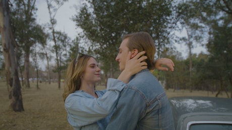 Romantic couple embracing in the middle of a forest.