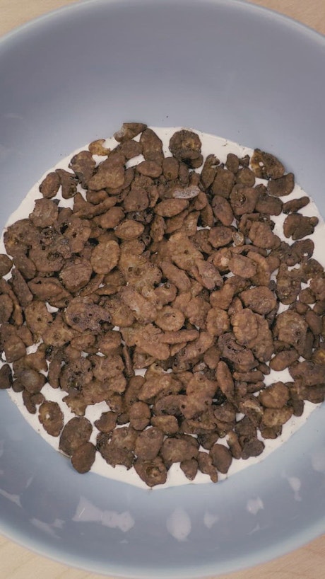 Rotating shot of a bowl of chocolate flavored cereal.