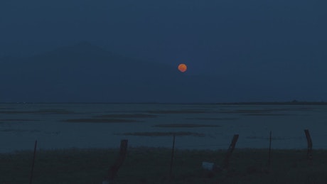 Skyline of a desert with the moon at night.