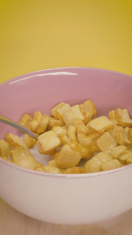 Taking cereal with milk from a bowl with a spoon.