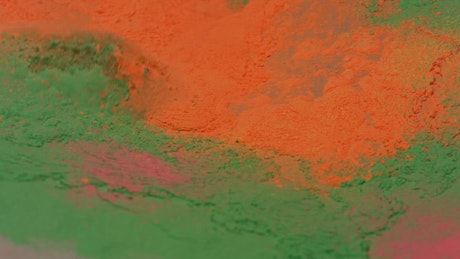 Texture of colorful powder being shaken in slow motion.