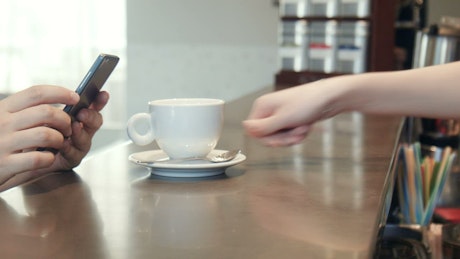 The waitress serving coffee in the counter.