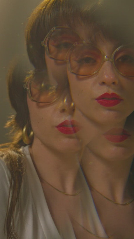 Vertical shot of a young woman with red lipstick dancing..