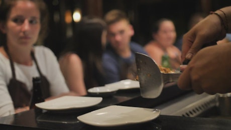 Waiter serving meat stew in a restaurant.