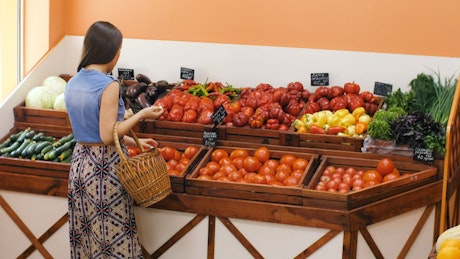 Woman buying tomatoes in the market.