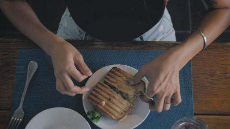 Woman eating salad and sandwich.