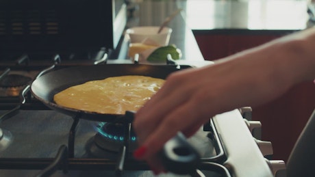 Woman flipping her egg omelet.