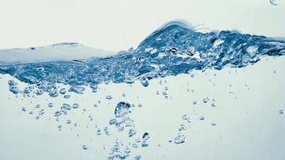 Many bubbles in water close up, abstract water wave with bubbles in slow motion.