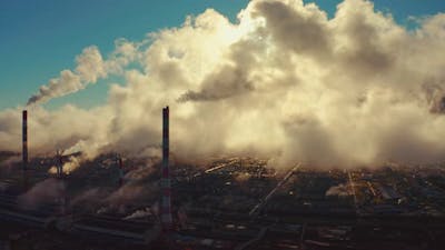 Power plant smokes. Aerial view of the power plant with smoking pipes and clouds passing by.