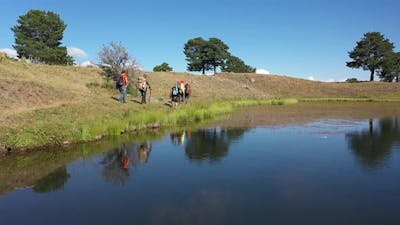 Group Of People Trekking By The Lake.