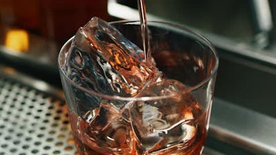 Close up of a professional bartender is preparing an alcoholic cocktail with professional crystal .