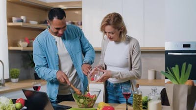 Happy Attractive Family Cooking Salad Together at Modern Kitchen..