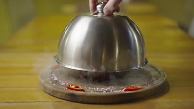 Serving Barbecue Ribs with Smoke Under the Lid in a Restaurant.