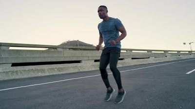 Wellness, sport or black man runner for running warm up, sports exercise or workout on city bridge.