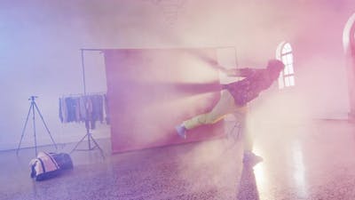 Happy biracial male dancer dancing alone in dance studio, slow motion.