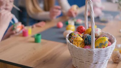 A Basket Filled with Colorful Easter Eggs is Placed on a Wooden Table Easter Concept.
