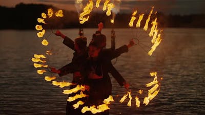 Young Women Dancing With Fire In Night Professional Fire Show Girls Rotating Fire Torches.