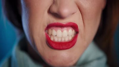 Portrait of the woman with red lips. Woman with bright red lips grins.