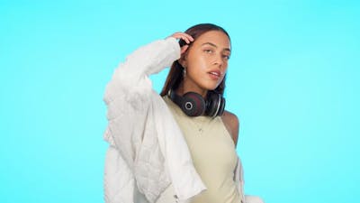 Fashion, portrait of woman with headphones and against a blue background.