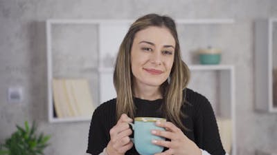 Woman drinking hot fresh coffee and smelling coffee..